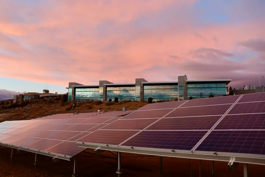Zonnepanelen op een dak bij zonsondergang